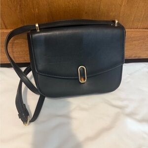 A New Day Black Crossbody Bag with Gold Details.